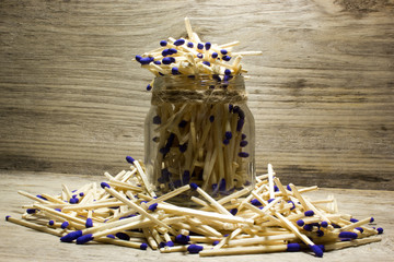 Matches with blue heads in jar on wooden background