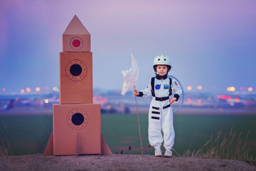 Adorable little boy, dressed as astronaut, playing in the park w