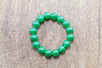 Green round stone  bracelet on vintage grunge wooden background