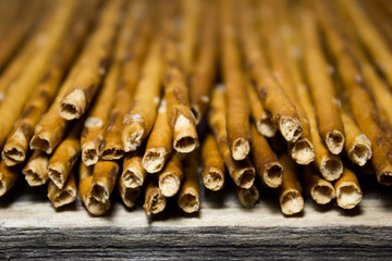 Bread sticks with salt on wooden background