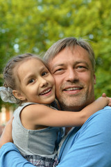 father with daughter in summer park