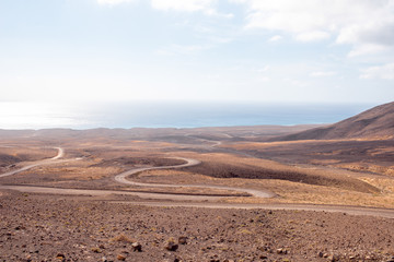 Fototapeta na wymiar Deserted landscape with ground road on Jandia peninsula on Fuerteventura island in Spain