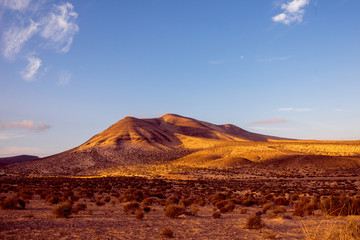 Fototapeta na wymiar Beautiful deserted landscape with soft mountains on Fuerteventura island in Spain