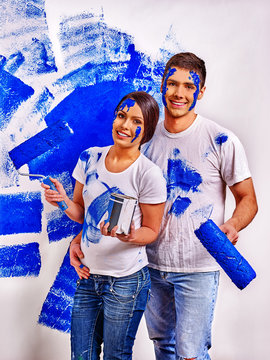 Happy Newlyweds Family Paint In Blue Wall At Home.