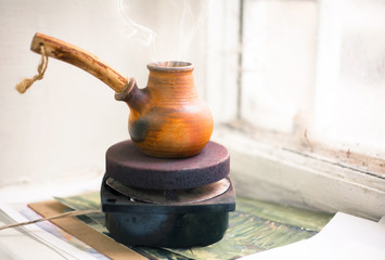 Cezve of coffee on a small stove