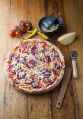 Delicious pizza with salami, tomatoes and cheese
