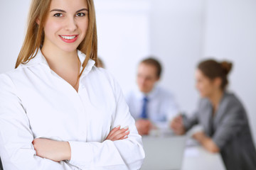 Fototapeta premium Beautiful business woman on the background of business people during meeting