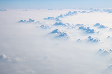 Fototapeta na wymiar Clouds in blue sky, aerial view from airplane window.