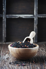 Fototapeta na wymiar Delicious black tea with petals on the wooden table