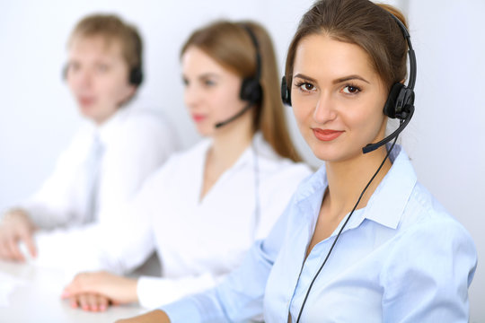 Call center. Focus on beautiful woman in headset