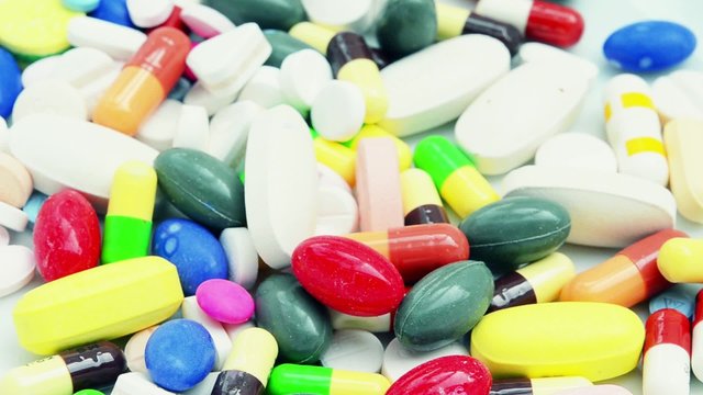 Closeup Pile of colorful medical medicine pills and capsule drugs pouring into mojo retro color style