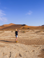 Eine Frau trinkt aus einer Wasserflasche, Sossusvlei, Naukluft Park, Rand der Namib Wüste, Hardap, Namibia , Afrika