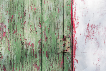 Wooden door with pealing paint and rusty hinges