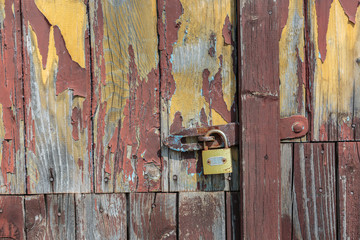 Wooden door with pealing paint and rusty hinges