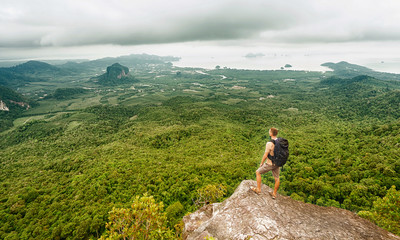 Freedom traveler man standing and enjoying a beautiful nature from top of mountain. Thailand. Krabi.