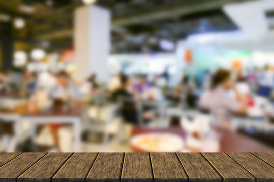 blurry defocused image of people eating food in food court