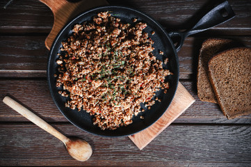 buckwheat with minced meat and vegetables on the wooden table
