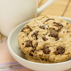 Chocolate chip cookies with coffee cup on wooden.