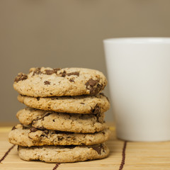Chocolate chip cookies with coffee cup on wooden.