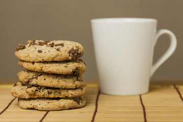 Chocolate chip cookies with coffee cup on wooden.