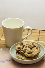 Chocolate chip cookies with coffee cup on wooden.