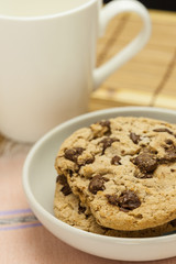 Chocolate chip cookies with coffee cup on wooden.