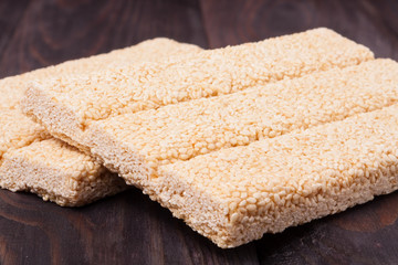 Honey bars with sesame seeds on wooden background