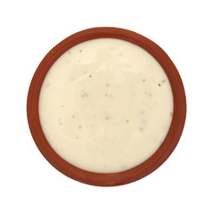 Bowl of ranch dressing on a white background top view
