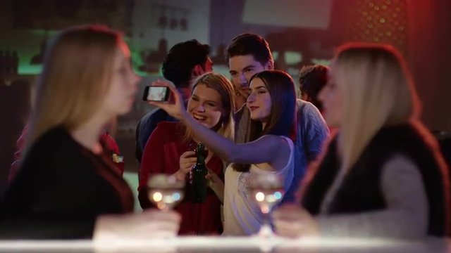 attractive young people in club taking a selfie on the dancefloor