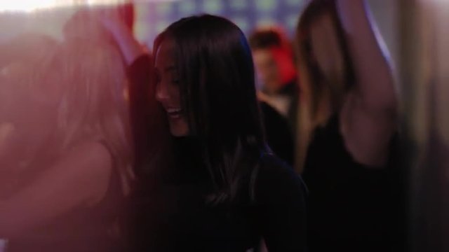 attractive long haired girl dancing in front of people at club