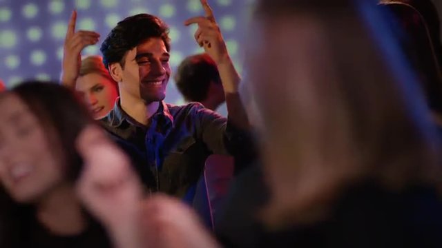attractive guy dancing at club looking at girls