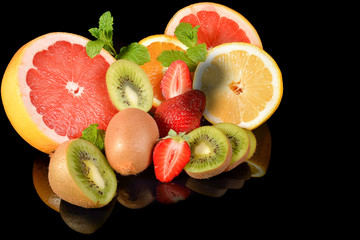 Fototapeta na wymiar strawberries, grapefruit, lemon, kiwi and oranges isolated on a black background with reflectionson 