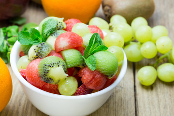 Naklejka na ściany i meble fruit salad with strawberries, oranges, kiwi, grape and watermel