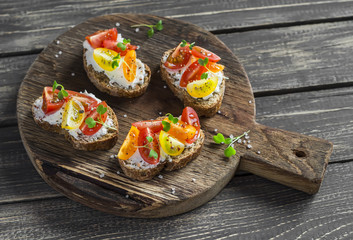 Tomato and cheese bruschetta on a rustic wooden cutting board. Healthy breakfast, snack or appetizer with wine