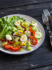 Fresh salad with cherry tomatoes, cucumbers, sweet peppers, celery and quail eggs. Healthy tasty food