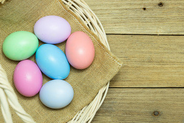 Easter eggs in the basket on wood background