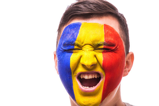 Scream in game emotions of Romanian football fan in game supporting of Romania national team on grey background. European 2016 football fans concept.