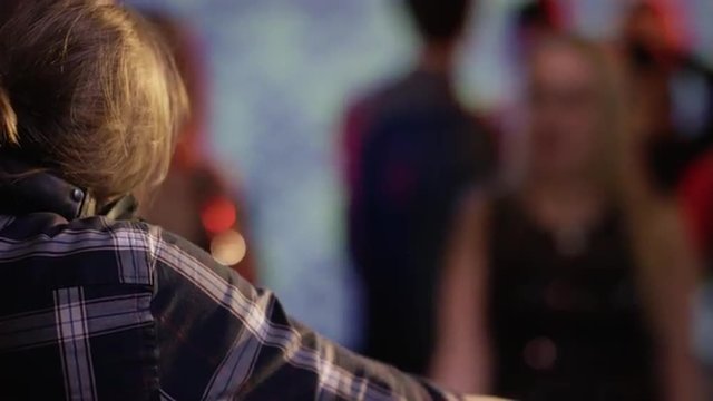 dj in the mix at club with crowd dacing in background