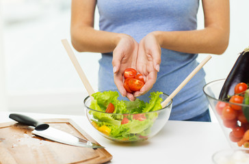 close up of woman cooking vegetable salad at home