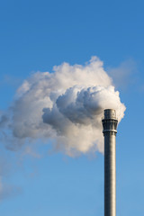 industry chimney with industrial smoke against the blue sky, copy space