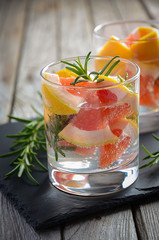 Summer refreshing drink with grapefruit and rosemary. Rustic background. Selective focus. Copy space.