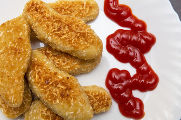 nuggets, breaded in a potato on a white plate