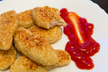 nuggets, breaded in a potato on a white plate
