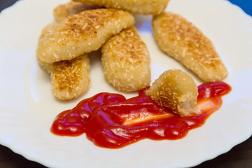 nuggets, breaded in a potato on a white plate