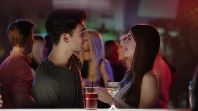 attractive couple kissing at bar in club