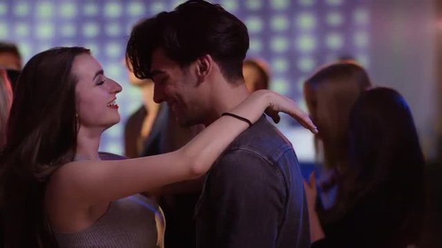 attractive couple on dancefloor at club flirting and dancing close