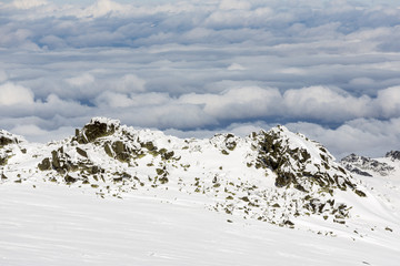 Fototapeta na wymiar Rocky mountain top in snow cloudy