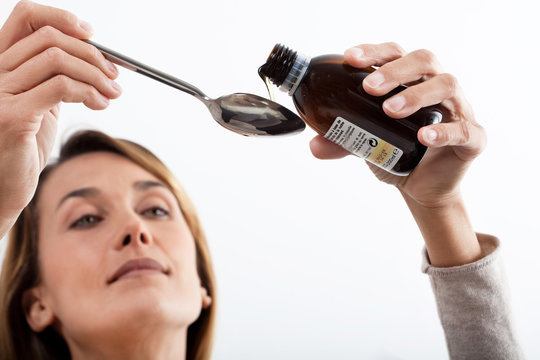 femme malade qui prend du sirop 