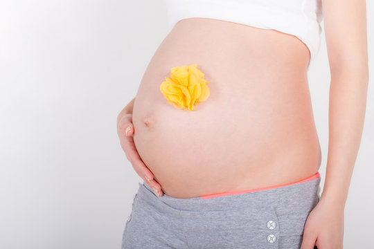 Young pregnant woman / teenager in white cloth with a gift yellow bow waiting for a baby