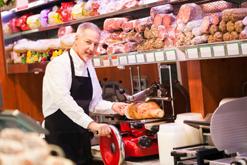 Shopkeeper cutting ham